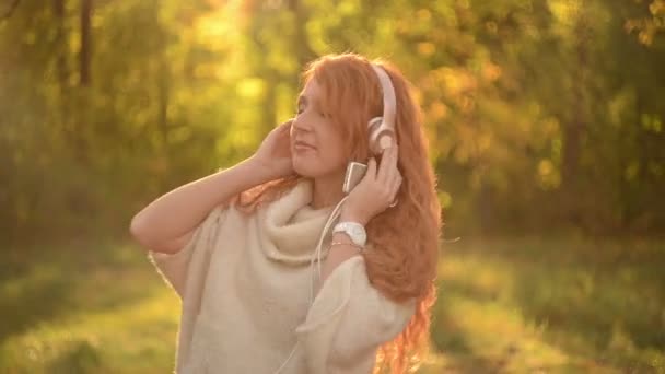 Красивая женщина слушает музыку в наушниках — стоковое видео