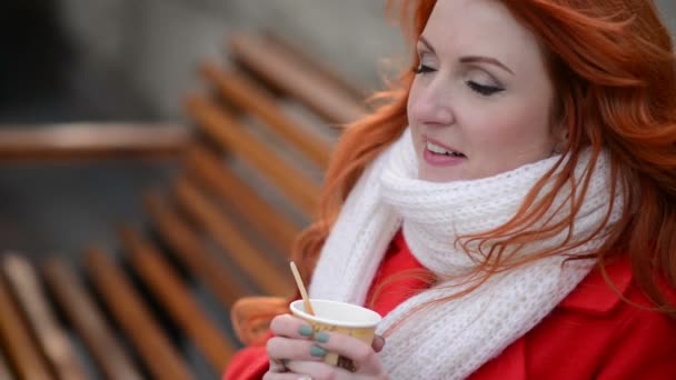 Жінка п'є гарячу каву, холодний осінній день — стокове відео