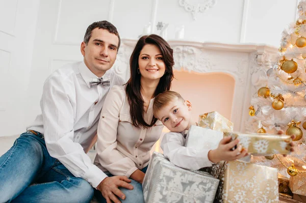 Familie am Kamin mit Weihnachtsgeschenken — Stockfoto