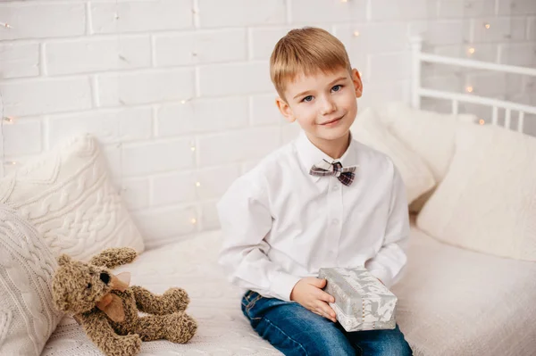 Niño pequeño sentado con regalo de Navidad en las manos —  Fotos de Stock