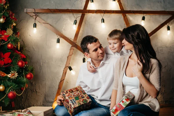 Feliz familia joven en las decoraciones de Navidad —  Fotos de Stock