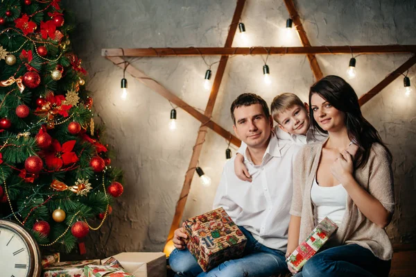 Feliz familia joven en las decoraciones de Navidad —  Fotos de Stock