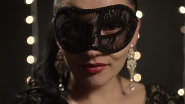 Woman in a Venetian mask on the background of night lights, close-up — Stock Video