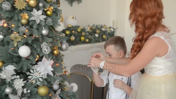 Příprava na Vánoce. Matka a syn zdobí vánoční strom. — Stock video