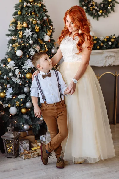 Madre e hijo de pie cerca de un árbol de Navidad —  Fotos de Stock