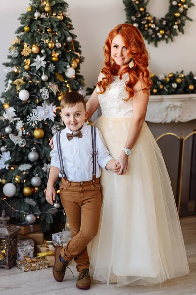 Madre e hijo de pie cerca de un árbol de Navidad —  Fotos de Stock