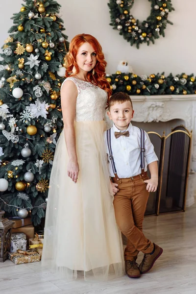 Madre e hijo de pie cerca de un árbol de Navidad —  Fotos de Stock