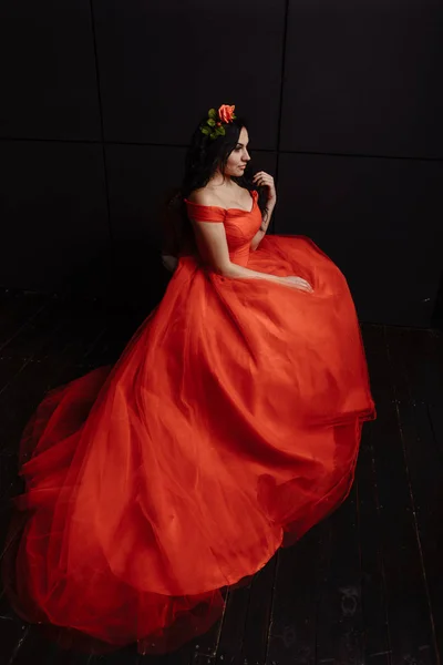 Красива жінка в розкішній червоній сукні на чорному тлі — стокове фото