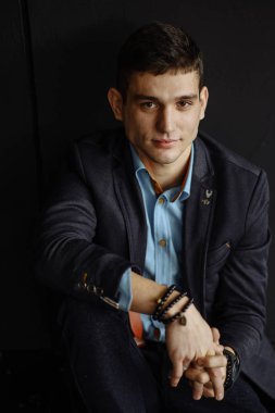 katta oturan genç şık giyimli adam