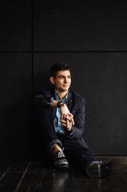 katta oturan genç şık giyimli adam