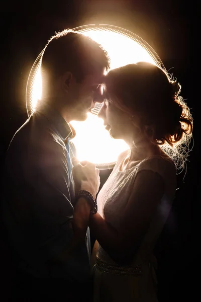 Liebender Mann und Frau im Lichtstrahl auf schwarzem Hintergrund — Stockfoto