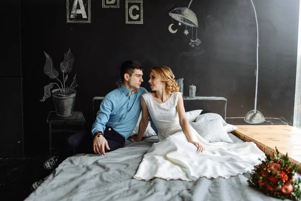 Joven pareja en amor abrazos en la cama en casa —  Fotos de Stock