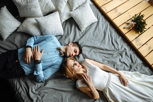 Молода пара закохалася в сміття на ліжку вдома — стокове фото