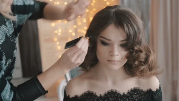 Hairdresser makes hairstyle for beautiful woman — Stock Video