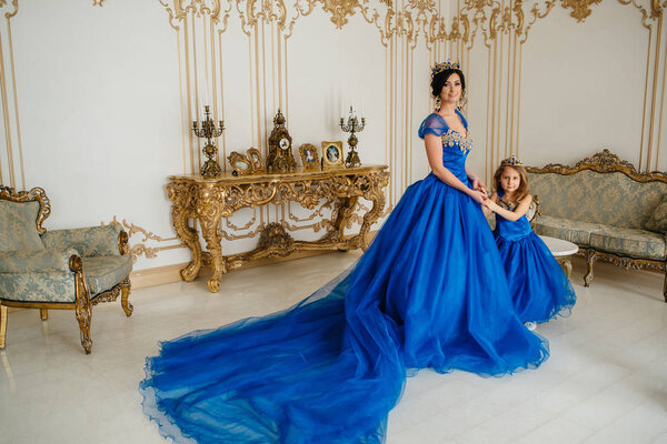 Красивая принцесса мать и дочь в золотой короне
