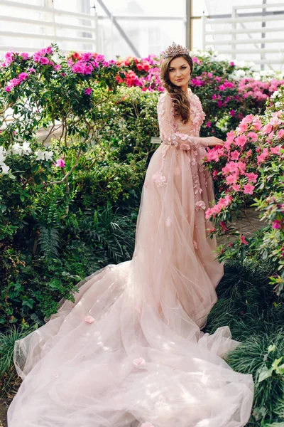 Beautiful woman in a peach-colored dress with a long train