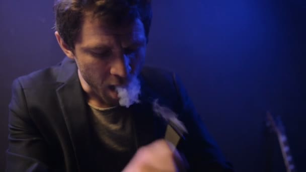 Молодий чоловік парі з електронною сигаретою і зробити деякі димові хмари — стокове відео