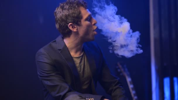 Молодий чоловік парі з електронною сигаретою і зробити деякі димові хмари — стокове відео