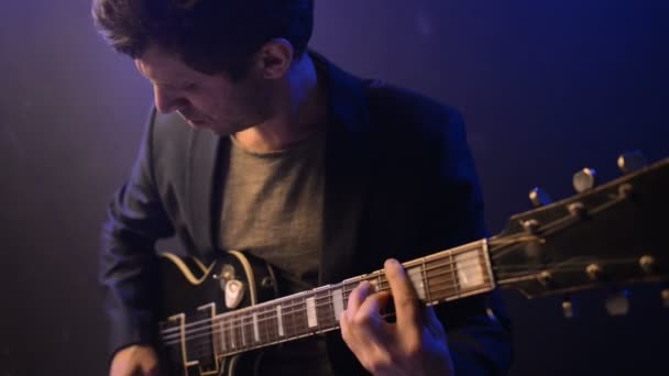 Homme est assis et joue de la guitare dans une pièce sombre — Video