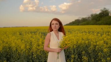 Saç çiçekli alanın ortasında uçan ile genç Kızıl saçlı kadın