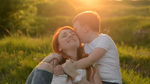 Anya és fia szórakozás kint ül a fűben — Stock videók