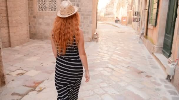 Ung kvinna promenader genom gatorna i en gammal europeisk stad — Stockvideo