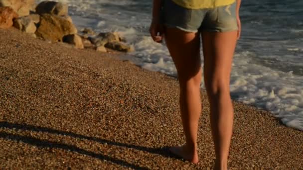 Ung kvinna i shorts vandring längs stranden av Adriatiska havet — Stockvideo