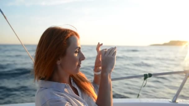 Genç kadın fotoğraf kamera telefonda bir tekne yolculuğu sırasında gemide çeker — Stok video