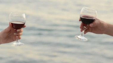 Aşıklar çifti ve arka plan üzerinde kırmızı şarap gözlükle deniz tıklatması