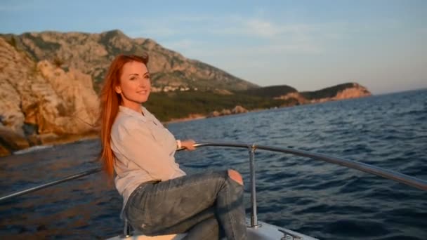Ung glad kvinna sitter i pågående cutter ser ut på Adriatiska havet — Stockvideo