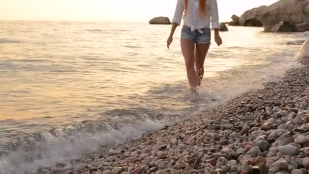 Young woman in shorts walking along the beach of the Adriatic Sea — Stock Video