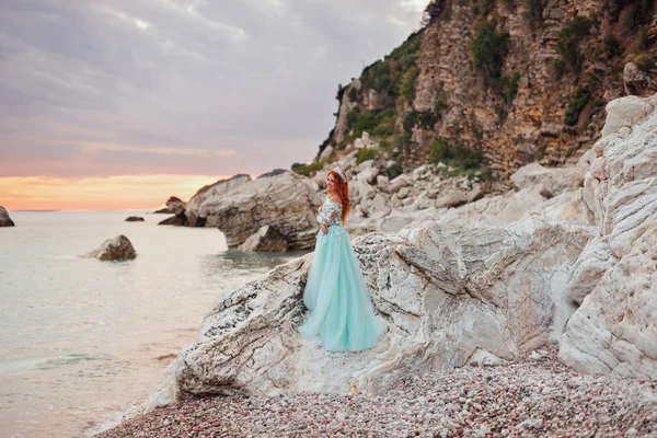 Jonge vrouw in een luxe jurk staat aan de oever van de Adriatische Zee — Stockfoto