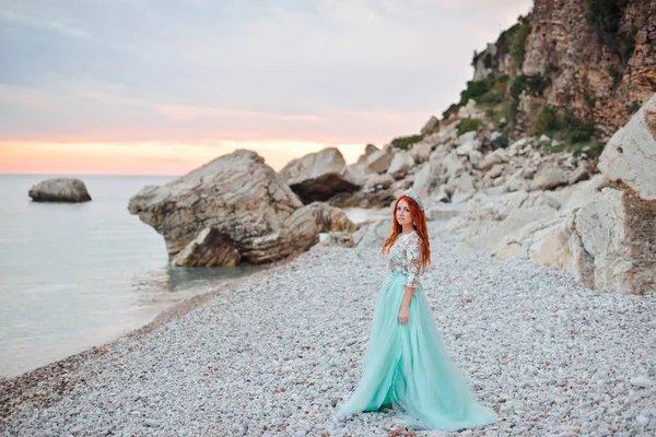 Молода жінка в розкішні сукні стоїть на березі Адріатичного моря — стокове фото