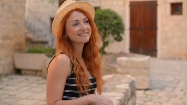 Kızıl saçlı kadın turist içme suyu bir antik kent sokak olduğunu