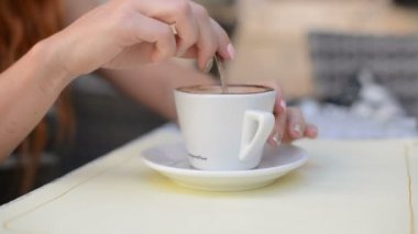 Kadın şeker bir fincan kahve kıpırdanırken.
