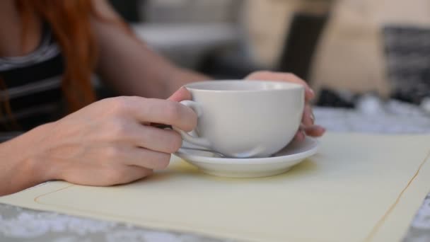 Vrouw neemt een kopje koffie uit de tabel — Stockvideo