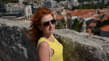 Saç eski şehrin arka plan üzerinde uçan ile Kızıl saçlı kadın