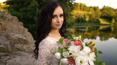 Genç gelin buketi elinde ile görünüyor kamera ve gülümsüyor, yakın çekim