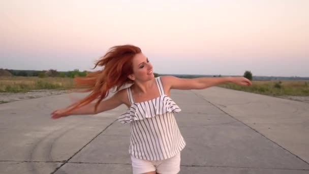 Mujer pelirroja feliz gira, su pelo revoloteando en el viento — Vídeos de Stock