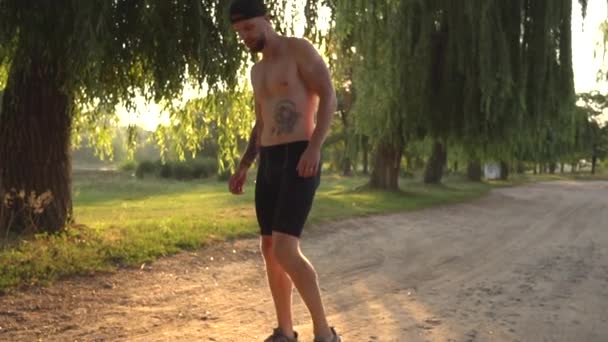 Ung man knådning innan jogging i naturen — Stockvideo