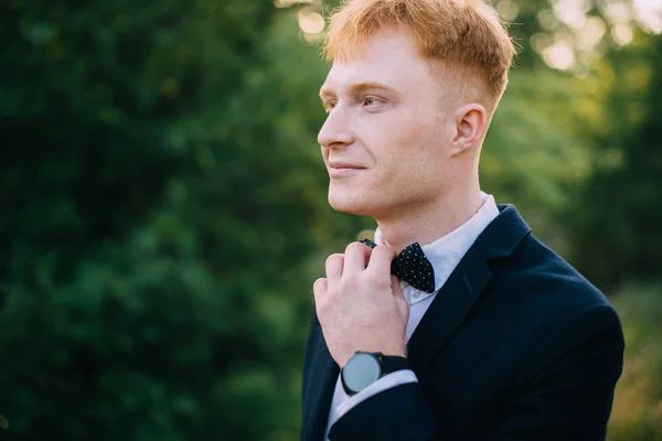 Man straightens bow-tie before the ceremony — Stock Photo, Image