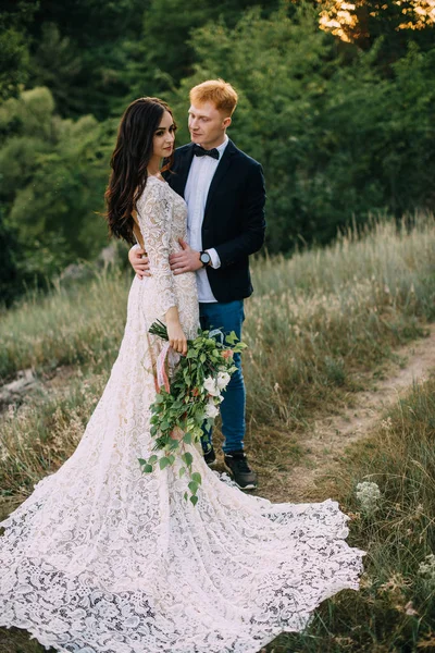 Feliz recém-casados de pé e abraçando — Fotografia de Stock