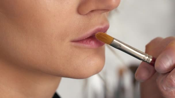 Визажист кладет основу для макияжа на губы — стоковое видео