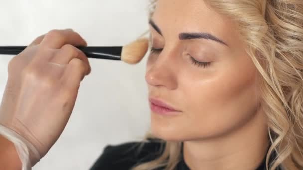 Make-up artist stawia podwaliny pod makijaż dziewczyna Blondynka — Wideo stockowe