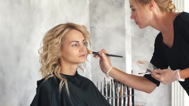 Make-up artist stawia podwaliny pod makijaż dziewczyna Blondynka — Wideo stockowe