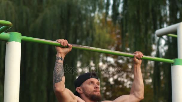 Muscular man doing pull-ups on horizontal bar — Stock Video