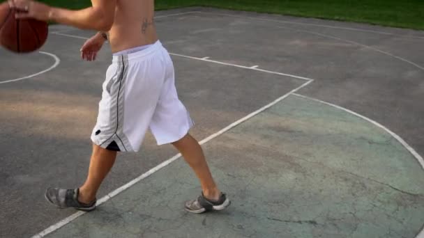 Junger Mann spielt Basketball und wirft den Ball in den Korb — Stockvideo