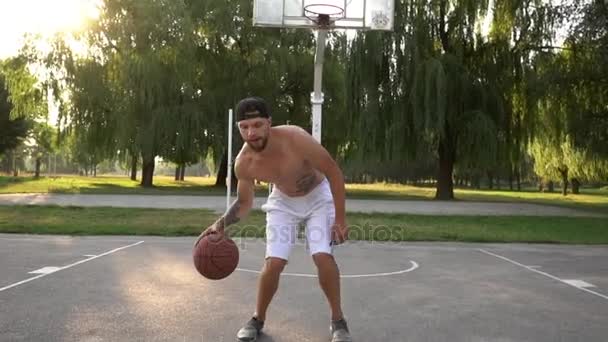 El hombre trata de vencer al oponente mientras juega baloncesto — Vídeos de Stock