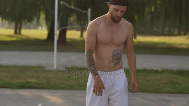 Hombre jugando baloncesto en la cancha de baloncesto, primer plano — Vídeo de stock