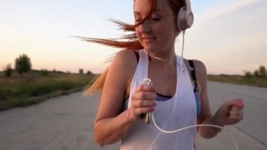 çalışan ve kulaklıklar müzik dinlemek kadın